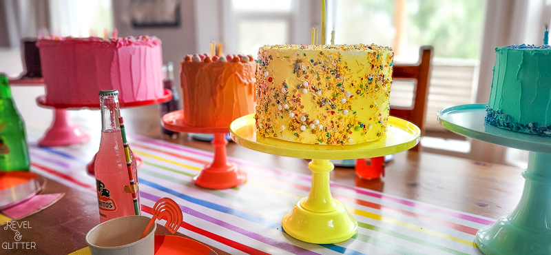 Wide shot of various Rainbow Cakes on coordinating cake stands